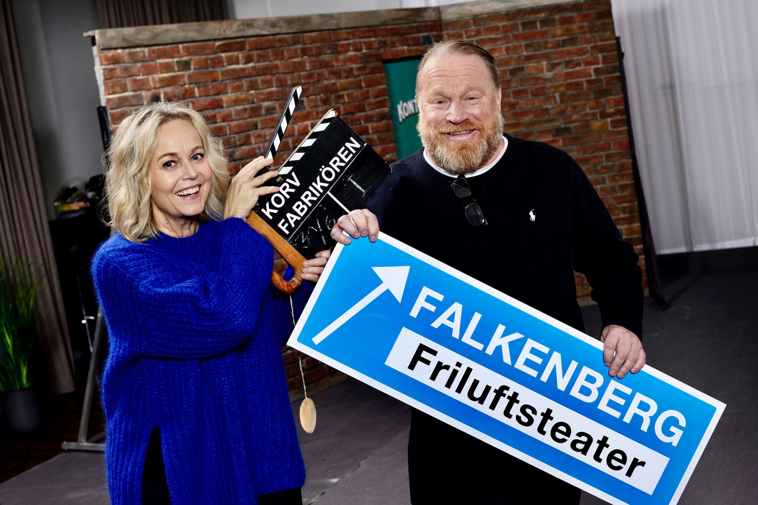 Producenten Annika Andersson och Claes Malmberg poserar med en skylt där det står 